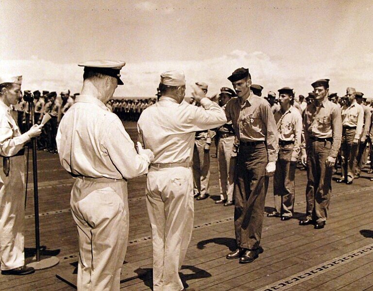 Rear Admiral Ralph Davidson presenting the Purple Heart to personnel onboard a carrier in July 7, 1944. Image courtesy of the National Archives.