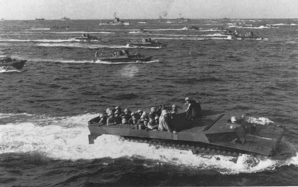 Tracked landing vehicles (LVTs), jam-packed with 4th Marine Division troops, approach the Line of Departure at H-hour on D-day.