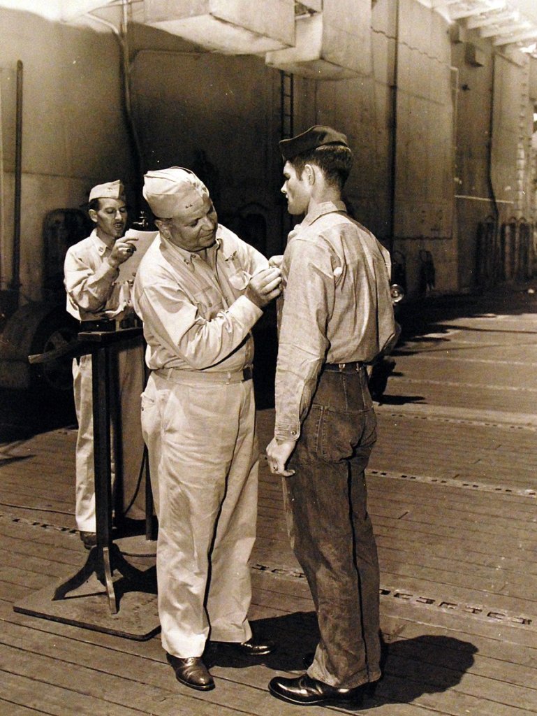 July 7, 1944. Rear Admiral Ralph Davidson presenting the Purple Heart to personnel onboard the carrier.